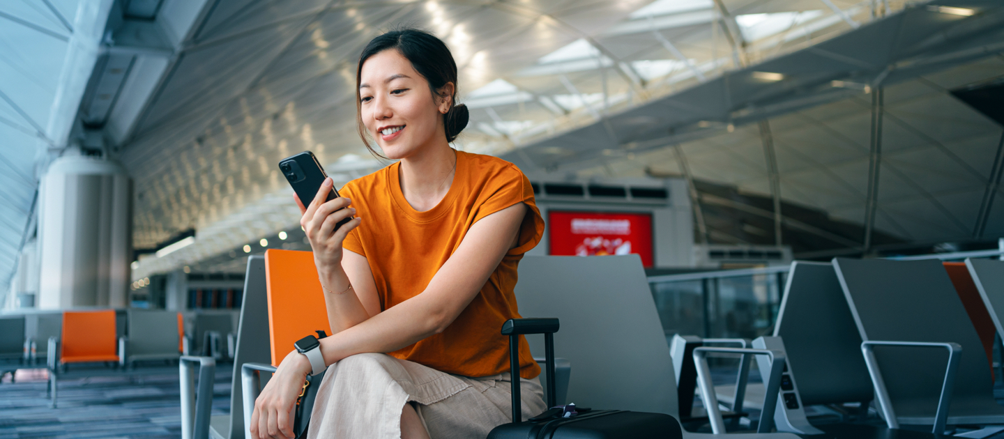 Woman looking at mobile phone in an airport.
