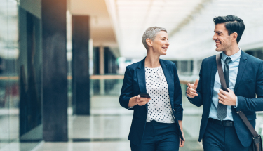 Two businesspersons walking together and talking