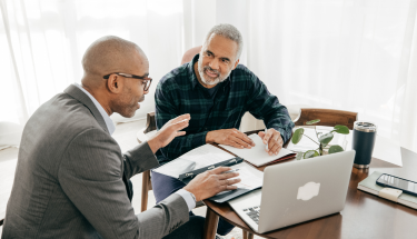 Smiling businesspeople reviewing paperwork together