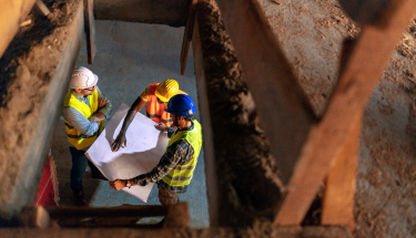 Three people looking at a construction blueprint