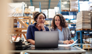 Female worker with supervisor working on laptop