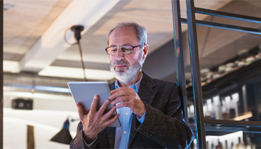 A businessman referring to the screen of his tablet