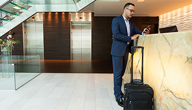A businessman walking down stairs holding a mobile phone in his hand
